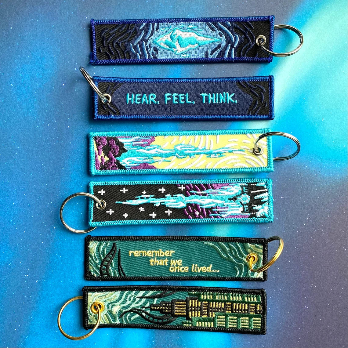Set of colorful keychains with text and designs on a blue background