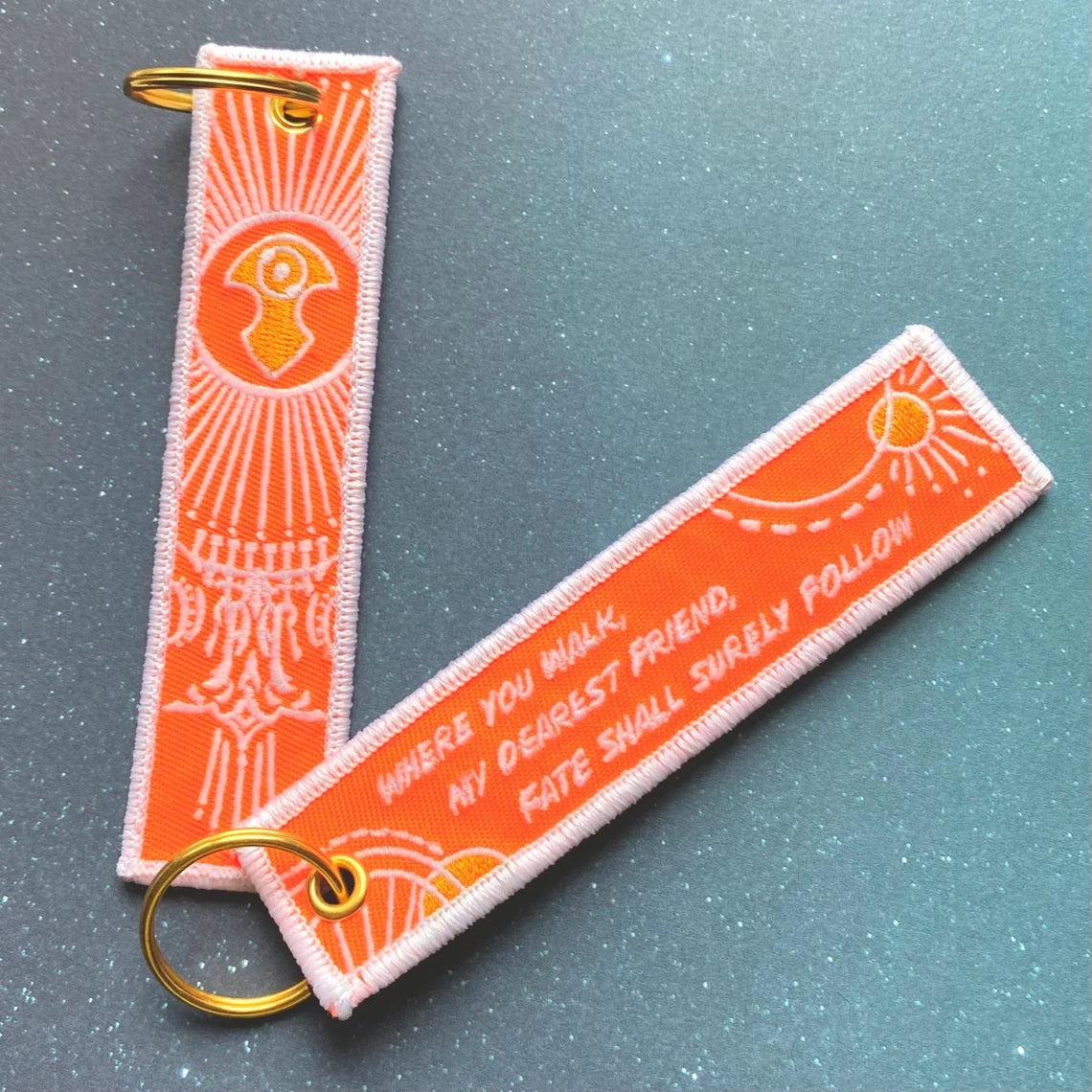 Orange and white keychain with Azem pattern.