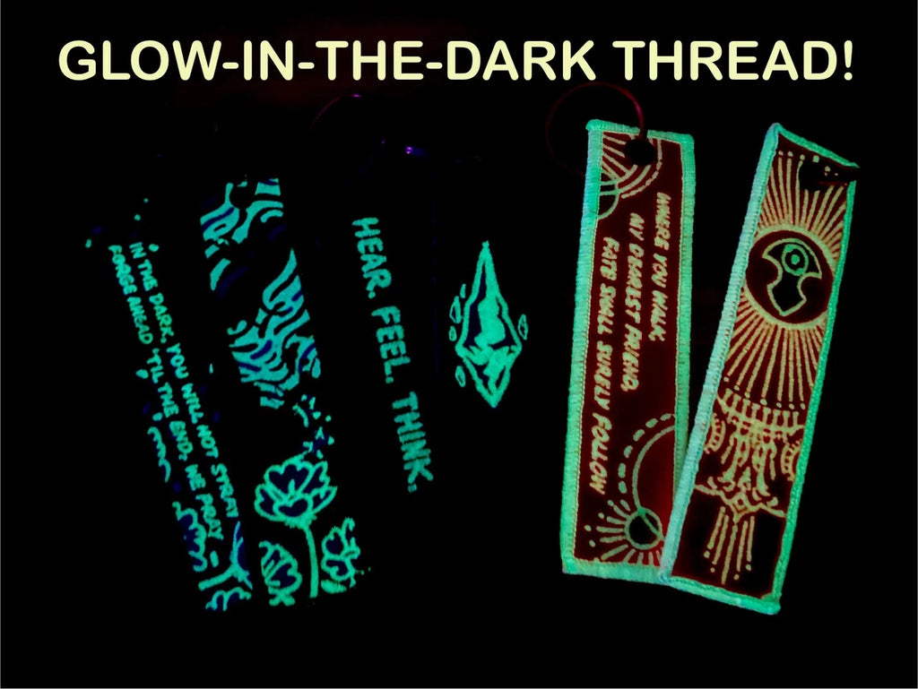 Glow-in-the-dark thread samples on a black background.